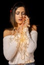 Young woman holding Christmas's string lights