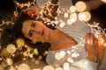 Young woman holding Christmas's string lights