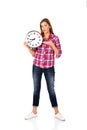 Young woman holding clock and pointing for it Royalty Free Stock Photo
