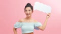 Young woman holding cloud speech bubble standing over isolated pink background with a happy face Royalty Free Stock Photo