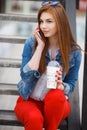 A young woman, holding a cocktail and making a phone call on a mobile phone Royalty Free Stock Photo