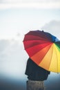 Young Woman holding colorful umbrella looking rain in the mountains with dramatic sky at sunset. retro and vintage style Royalty Free Stock Photo