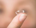 Contact lens on finger in front of face