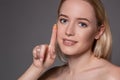 Young woman holding contact lens on index finger with copy space. Close up face of healthy beautiful woman about to wear Royalty Free Stock Photo