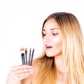 Young woman is holding cosmetic brushes. Make-up