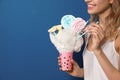 Young woman holding cotton candy dessert on blue background, closeup Royalty Free Stock Photo