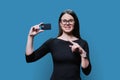 Young woman holding credit card in her hands on blue background Royalty Free Stock Photo