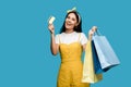 Young woman holding credit card and shopping bags isolated on blue Royalty Free Stock Photo