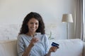 Young woman holding credit card and smartphone buying on internet Royalty Free Stock Photo