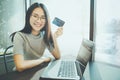 Young woman holding credit card and using laptop computer. Businesswoman or entrepreneur working. Online shopping, E-commerce. Int Royalty Free Stock Photo