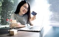 Young woman holding credit card and using laptop computer. Businesswoman or entrepreneur working. Online shopping, E-commerce. Int Royalty Free Stock Photo