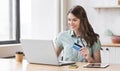 Young woman holding credit card and using laptop computer. Businesswoman or entrepreneur working. Royalty Free Stock Photo