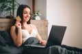 Young woman holding credit card and using laptop computer. Online shopping concept Royalty Free Stock Photo