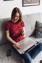 Young woman holding credit card, using laptop computer. Online shopping, paying from home Royalty Free Stock Photo