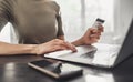 Young woman holding credit card and using laptop at home Royalty Free Stock Photo