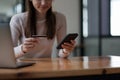 Young woman holding credit card and using smart phone for online shopping. Online payment shopping concept. Royalty Free Stock Photo