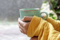 Young woman holding cup of morning coffee or tea in hands outdoors. Still life, self love and care concept.