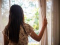Young woman holding the curtains open Royalty Free Stock Photo