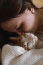 Woman at home holding her cat, room interior on the bed Royalty Free Stock Photo