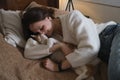 Woman at home holding her cat, room interior on the bed Royalty Free Stock Photo