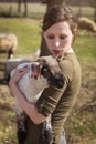 Young woman holding a cute lamb, affectionate breeding and care