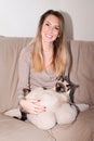 Young woman holding cute siamese cat hugging her cute pet kitty