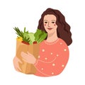 Young Woman holding eco vegetables in grocery paper bag. Vegan girl eat organic products. Vegetarian, vegan nutrition