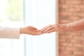 Young woman holding elderly man hand indoors Royalty Free Stock Photo