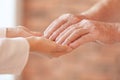 Young woman holding elderly man hands indoors Royalty Free Stock Photo