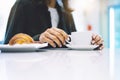 Young woman holding in female hands croissant and drink hot aroma coffee or tea in breakfast time, hipster traveler smile girl Royalty Free Stock Photo