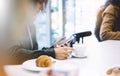 Young woman holding in female hands mobile phone and drink hot aroma coffee or tea in breakfast time, hipster traveler girl Royalty Free Stock Photo