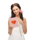 Young woman holding flower and postcard Royalty Free Stock Photo