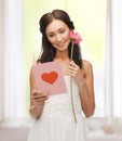 Young woman holding flower and postcard Royalty Free Stock Photo