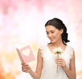 Young woman holding flower and postcard Royalty Free Stock Photo