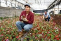 Young woman holding flower pot with impatiens waller