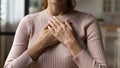 Young woman holding folded hands on chest heart. Royalty Free Stock Photo