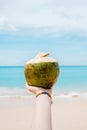 Young woman holding the fresh coconut on a beach