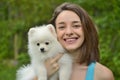 Young woman holding german spitz puppy