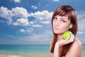 Young woman holding green apple near sea face close Royalty Free Stock Photo