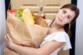 Young woman holding grocery shopping bag with vegetables. Paper package with food products in hands of woman housewife. Royalty Free Stock Photo