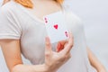 Young woman holding in hand poker card with combination of Full