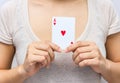 Young woman holding in hand poker card with combination of Full