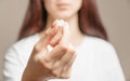 Woman holding a white round pill or vitamin. Royalty Free Stock Photo