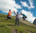 Young woman holding hands with two laughing man on a background of mountains Royalty Free Stock Photo