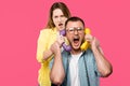 young woman holding handsets and man in eyeglasses yelling isolated