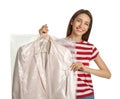 Young woman holding hanger with jacket in bag on white background. Dry-cleaning service Royalty Free Stock Photo