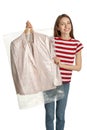 Young woman holding hanger with jacket in plastic bag on background. Dry-cleaning service Royalty Free Stock Photo