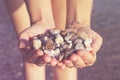 Young woman holding on her hand the beautiful colorful pebbles of Greek beaches Royalty Free Stock Photo