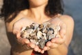 Young woman holding on her hand the beautiful colorful pebbles Royalty Free Stock Photo