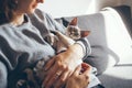 Young woman is holding and hugging his cute curious Devon Rex cat.